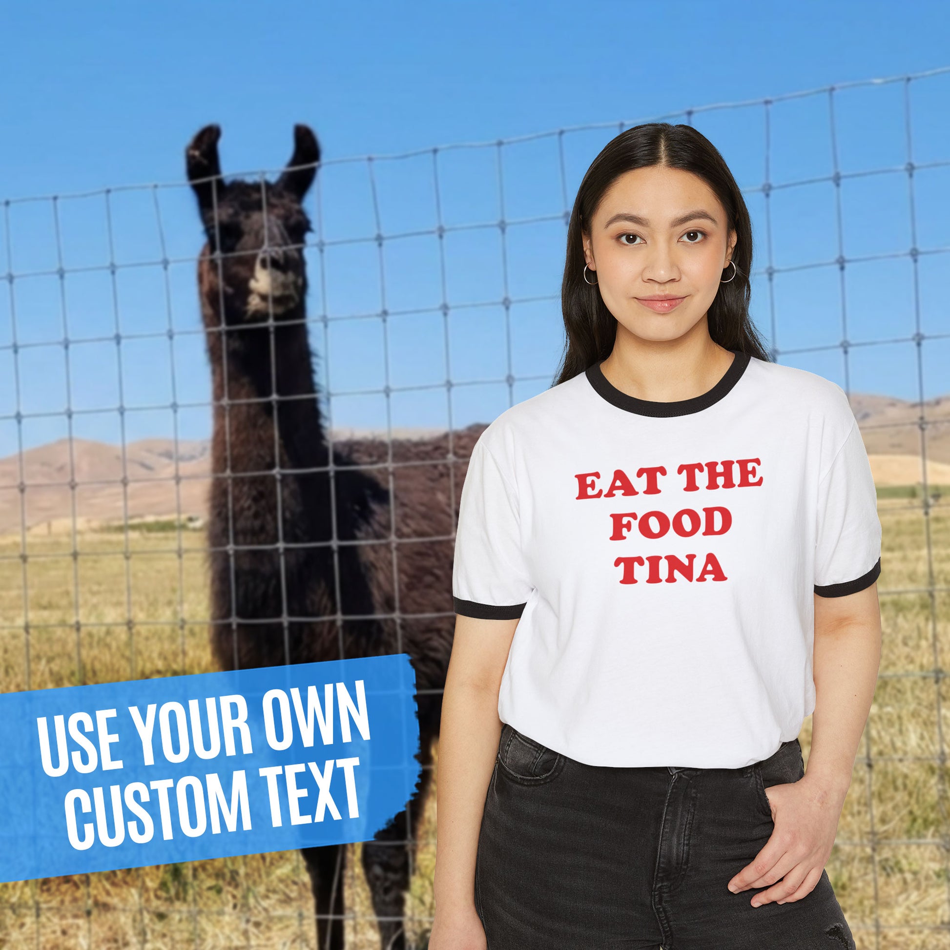 Woman wearing white ringer tee with black trim and red custom text, from Napoleon Dynamite, shown as “EAT THE FOOD TINA” near a llama