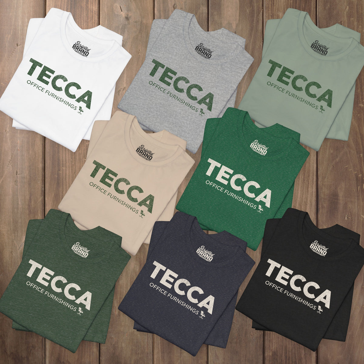 Eight folded TECCA Office Furnishings tees inspired by The Chair Company. Bella+Canvas tim robinson shirt comedy.
