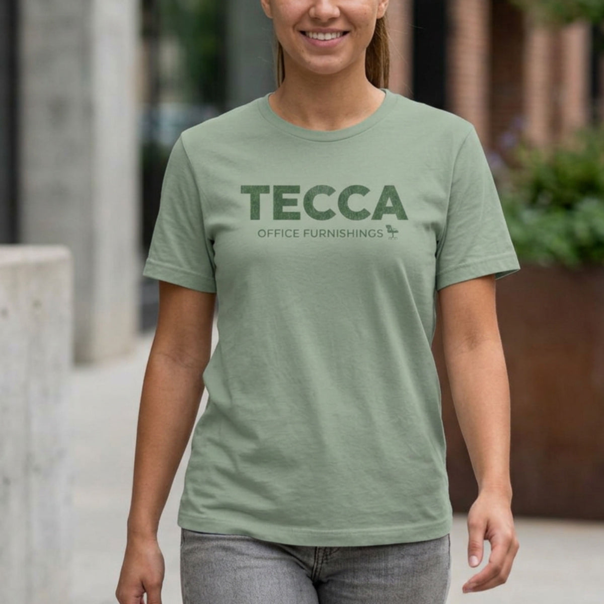 Person wearing sage green TECCA Office Furnishings tee inspired by The Chair Company. Bella+Canvas tim robinson shirt comedy.