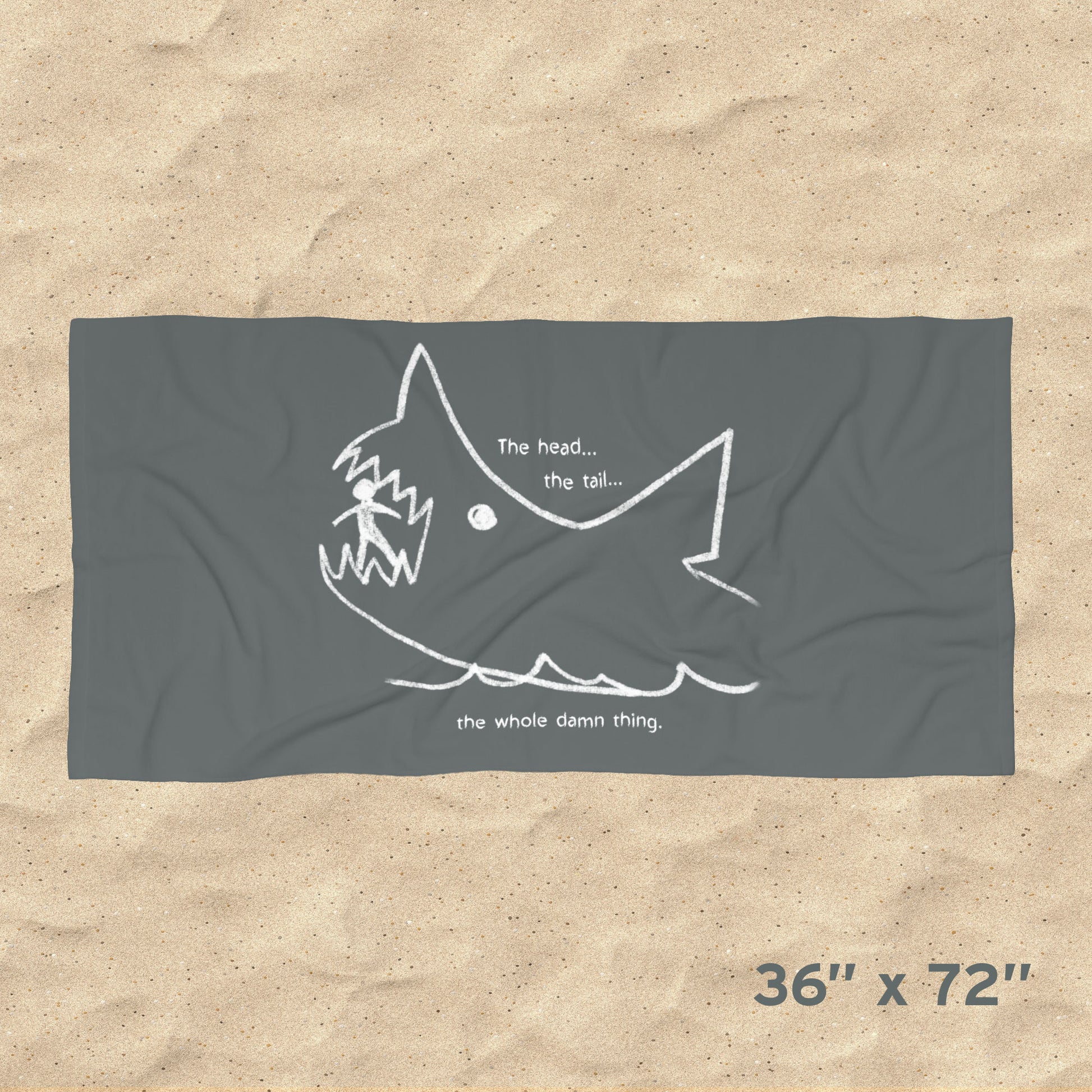 Overhead view of Jaws beach towel with gray Quint chalkboard shark drawing and “the whole damn thing” quote draped on beach chair, size 36x72.