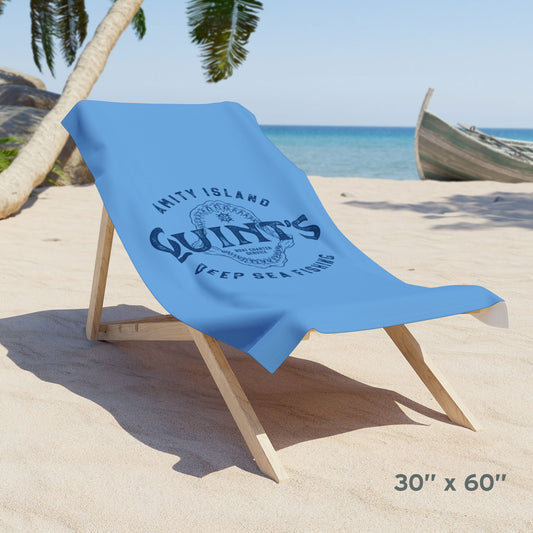 30x60 Blue beach towel with Quint’s Deep Sea Fishing logo, vintage distressed Jaws inspired design, shown draped over a beach chair.