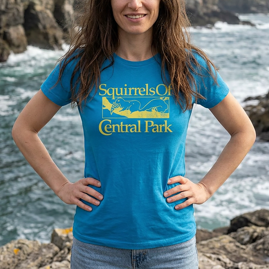 Person wearing a turquoise women’s t-shirt with distressed yellow “Squirrels of Central Park” logo inspired by TV show Bad Sisters.