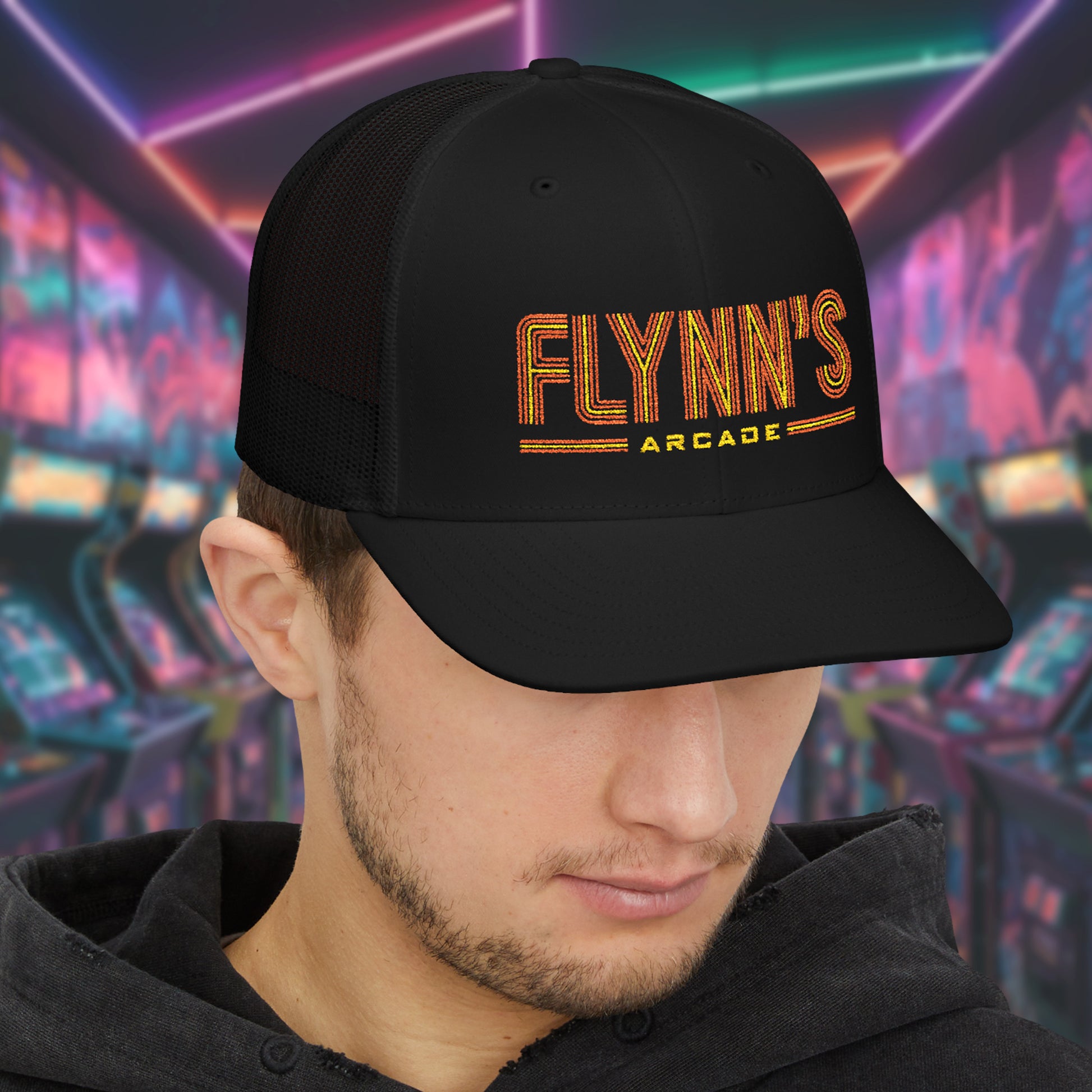 Man wearing Black Richardson 112 snapback trucker cap with 'Flynn’s Arcade' neon logo inspired by TRON.