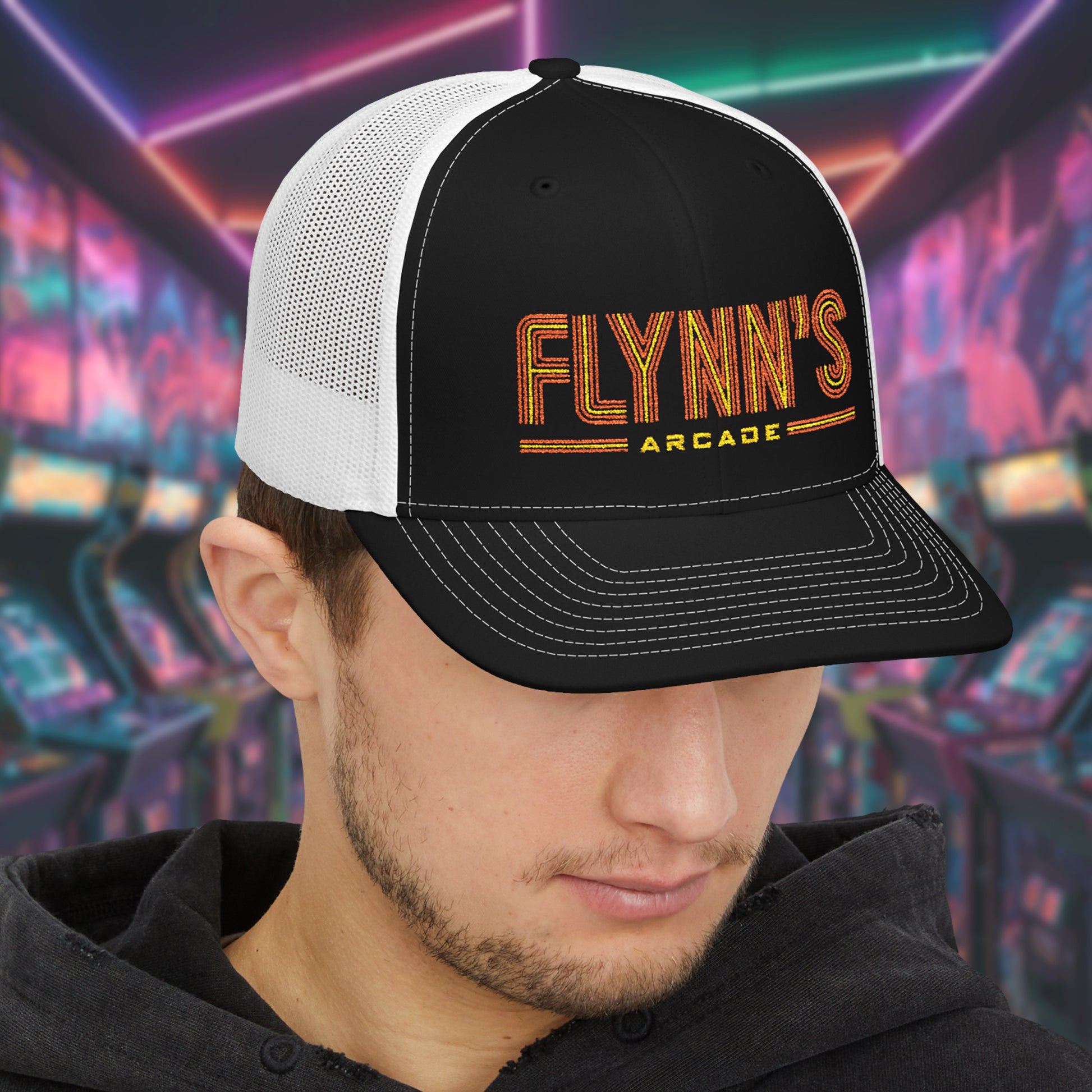 Man wearing Black and white Richardson 112 snapback trucker cap with 'Flynn’s Arcade' neon logo inspired by TRON.