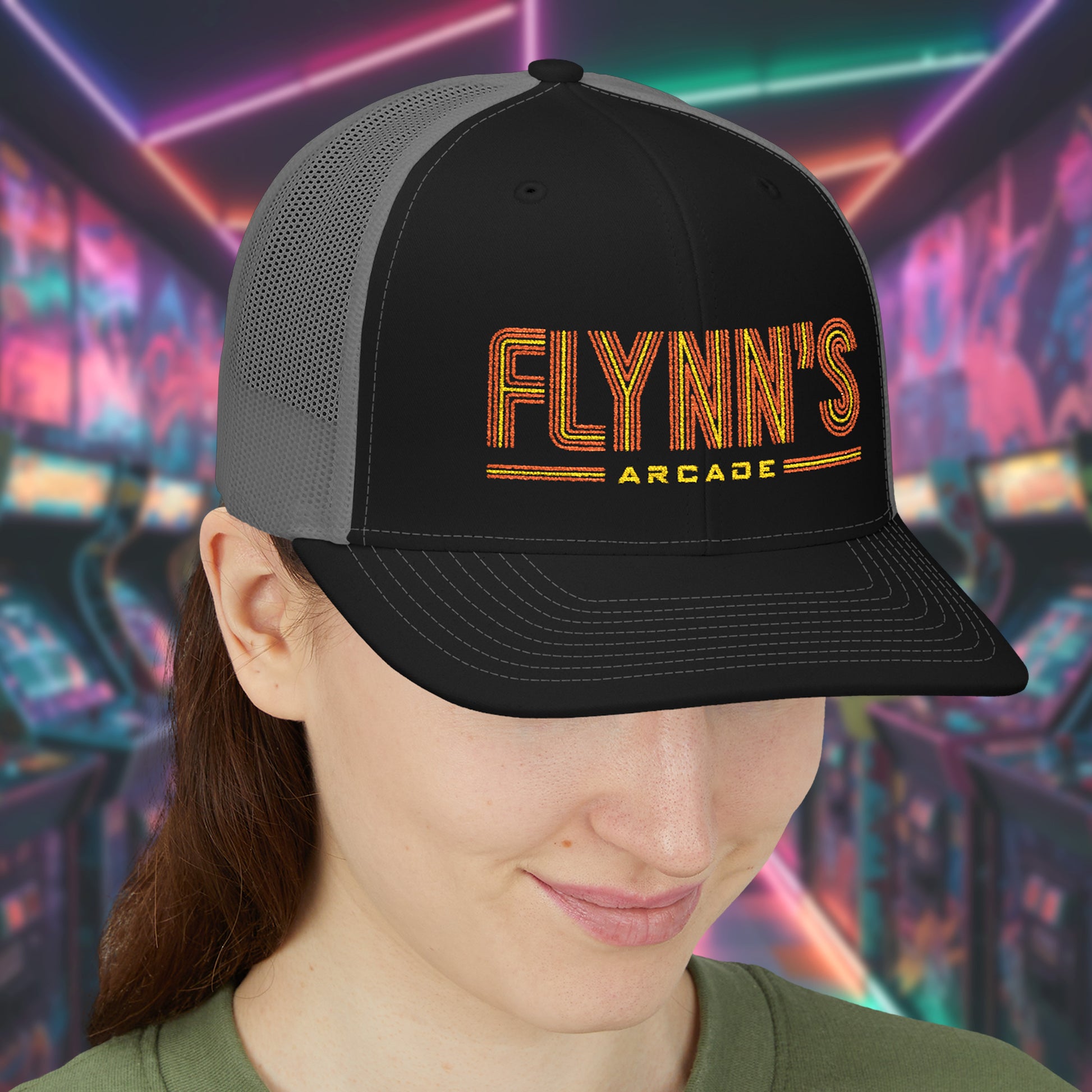 Woman wearing Black and charcoal Richardson 112 snapback trucker cap with 'Flynn’s Arcade' neon logo inspired by TRON.