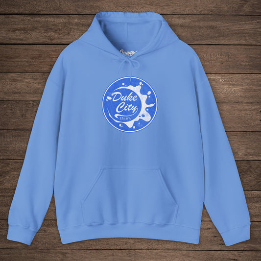 Light blue hoodie with 'Duke City Dairy' logo from Pluribus on a wooden background.