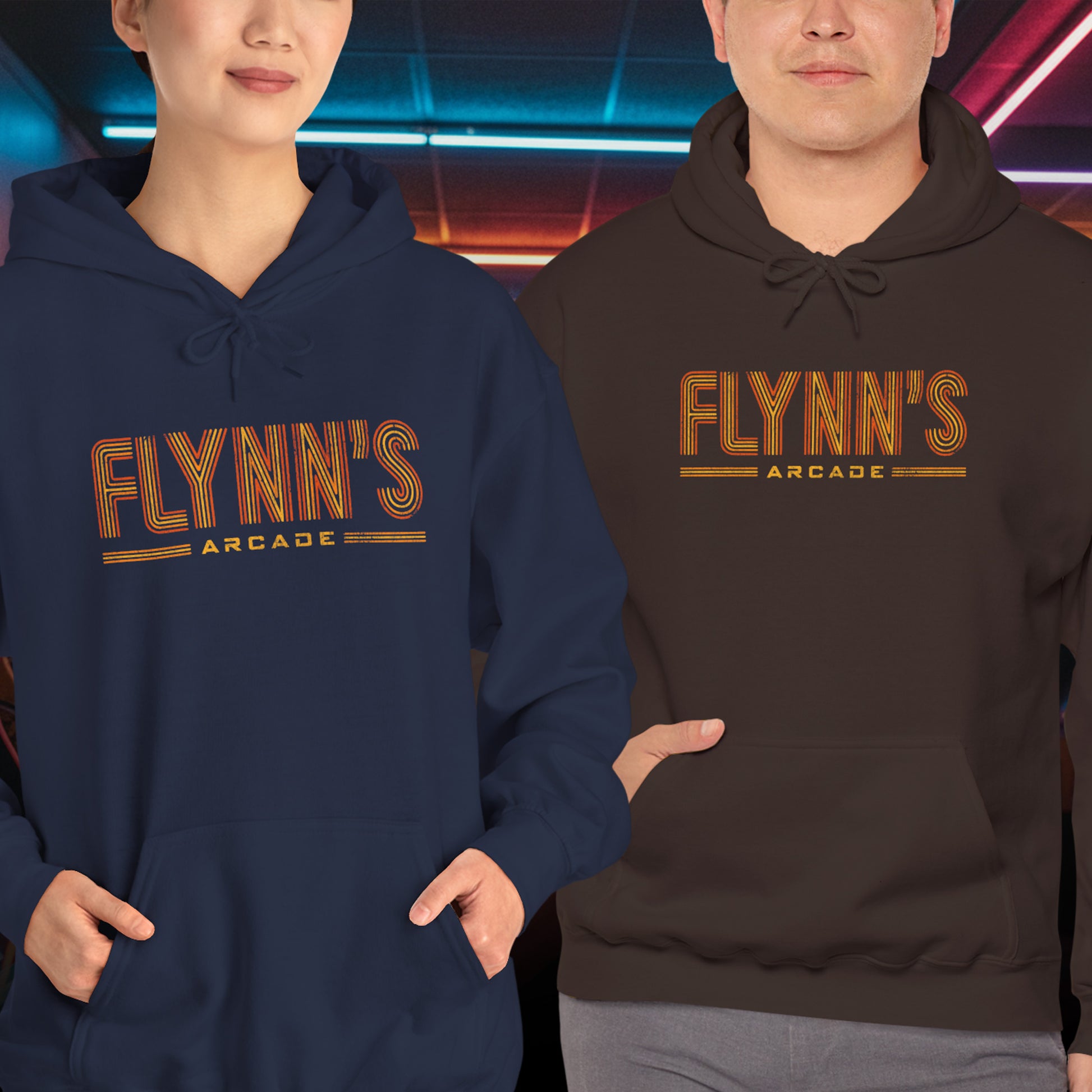 Two people wearing hoodie sweatshirts with vintage distressed 'Flynn’s Arcade' neon logo inspired by TRON