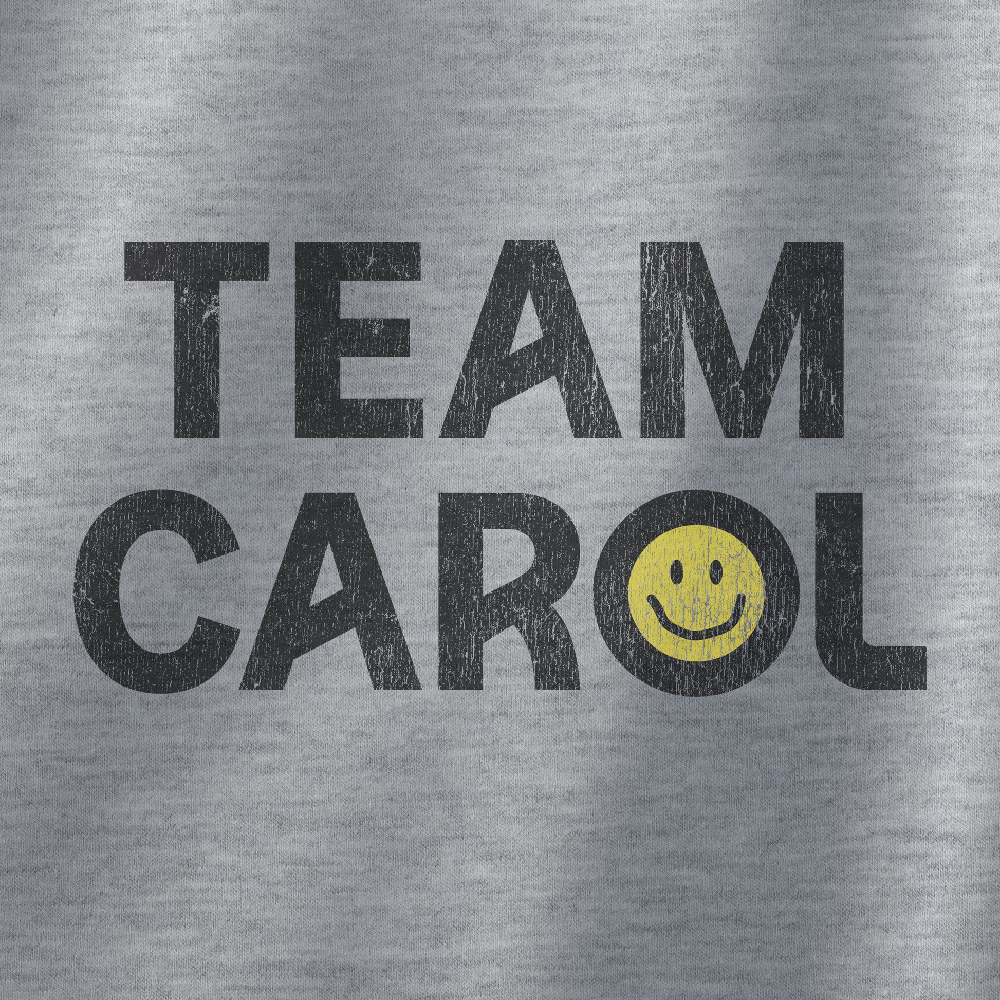 Closeup of heather gray unisex Heavy Blend pullover hoodie sweatshirt with TEAM CAROL vintage distressed smiley graphic