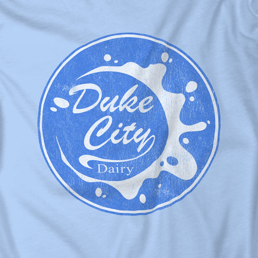 Closeup of Light blue t-shirt with vintage distressed Duke City Dairy logo inspired by TV Show Pluribus.