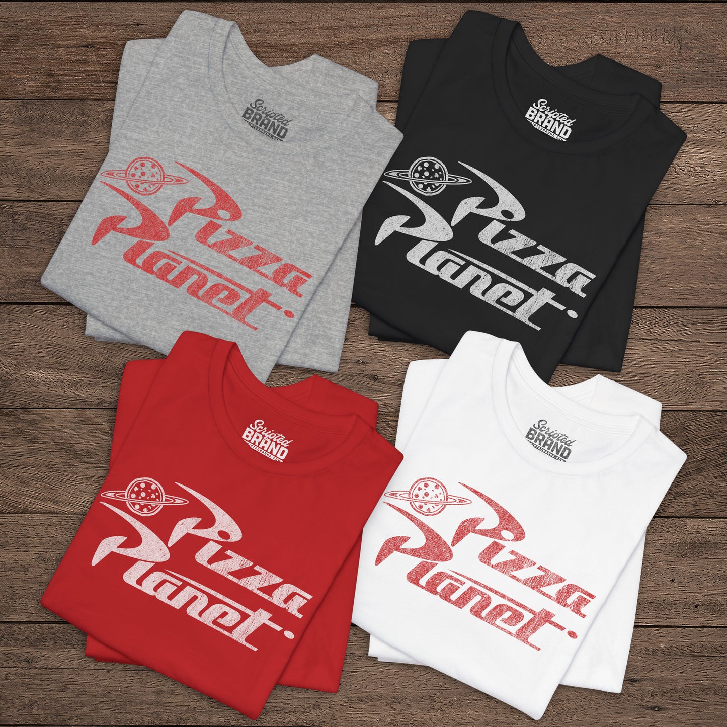 Four folded t-shirts with distressed Pizza Planet logo inspired by the Toy Story movies.
