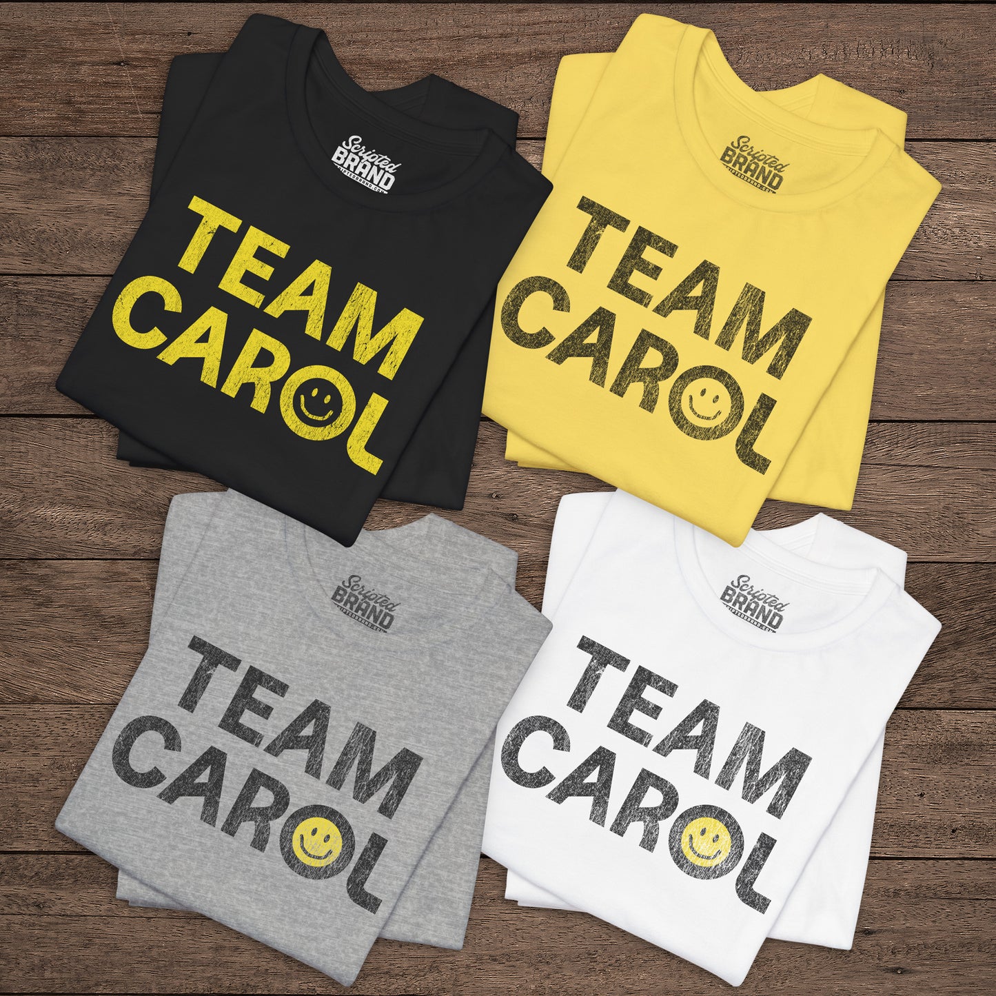 Four folded TEAM CAROL t-shirts inspired by Pluribus with vintage distressed smiley face graphics