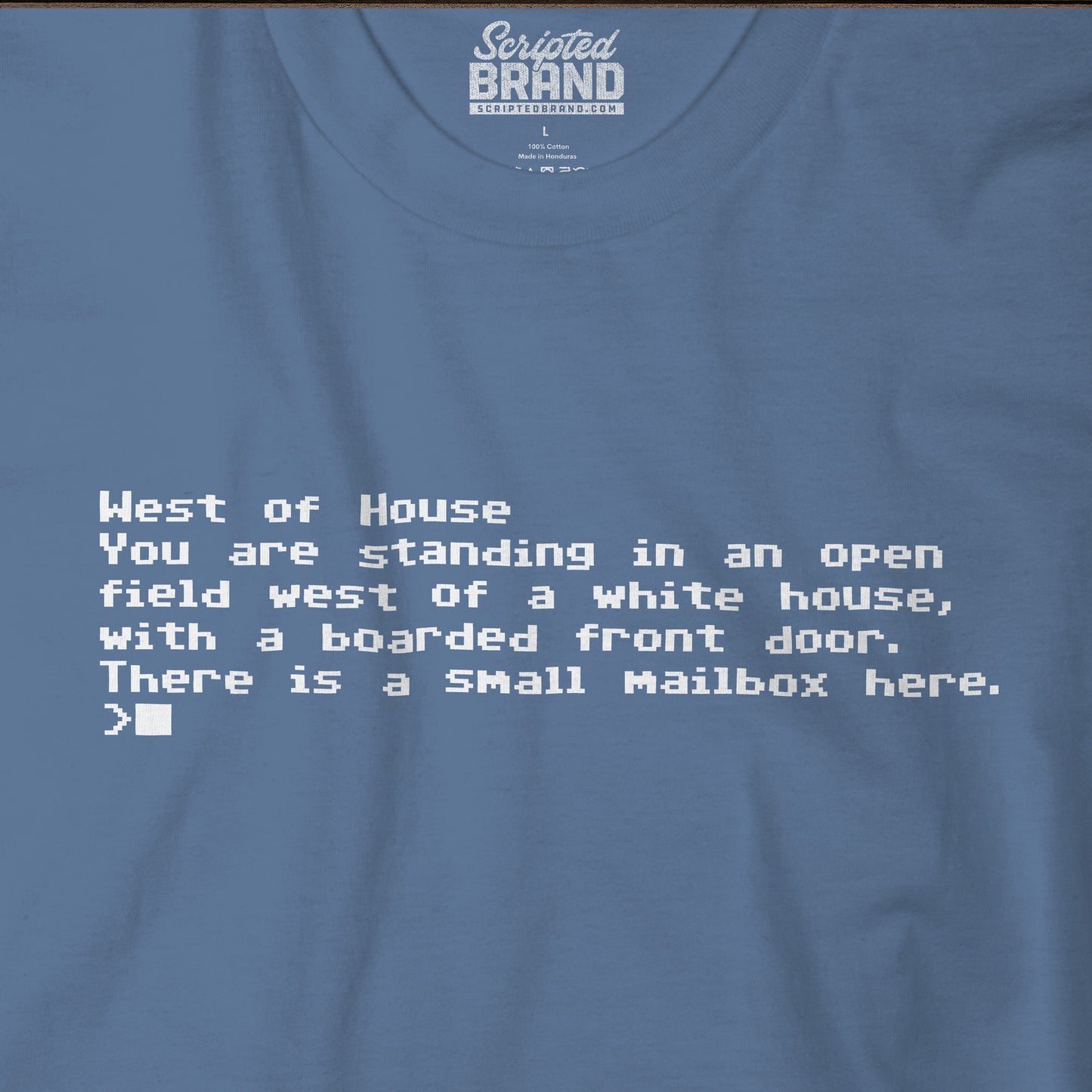 Closeup of blue Bella+Canvas 3001 Zork “West of House” text adventure quote t-shirt with terminal-style printed text