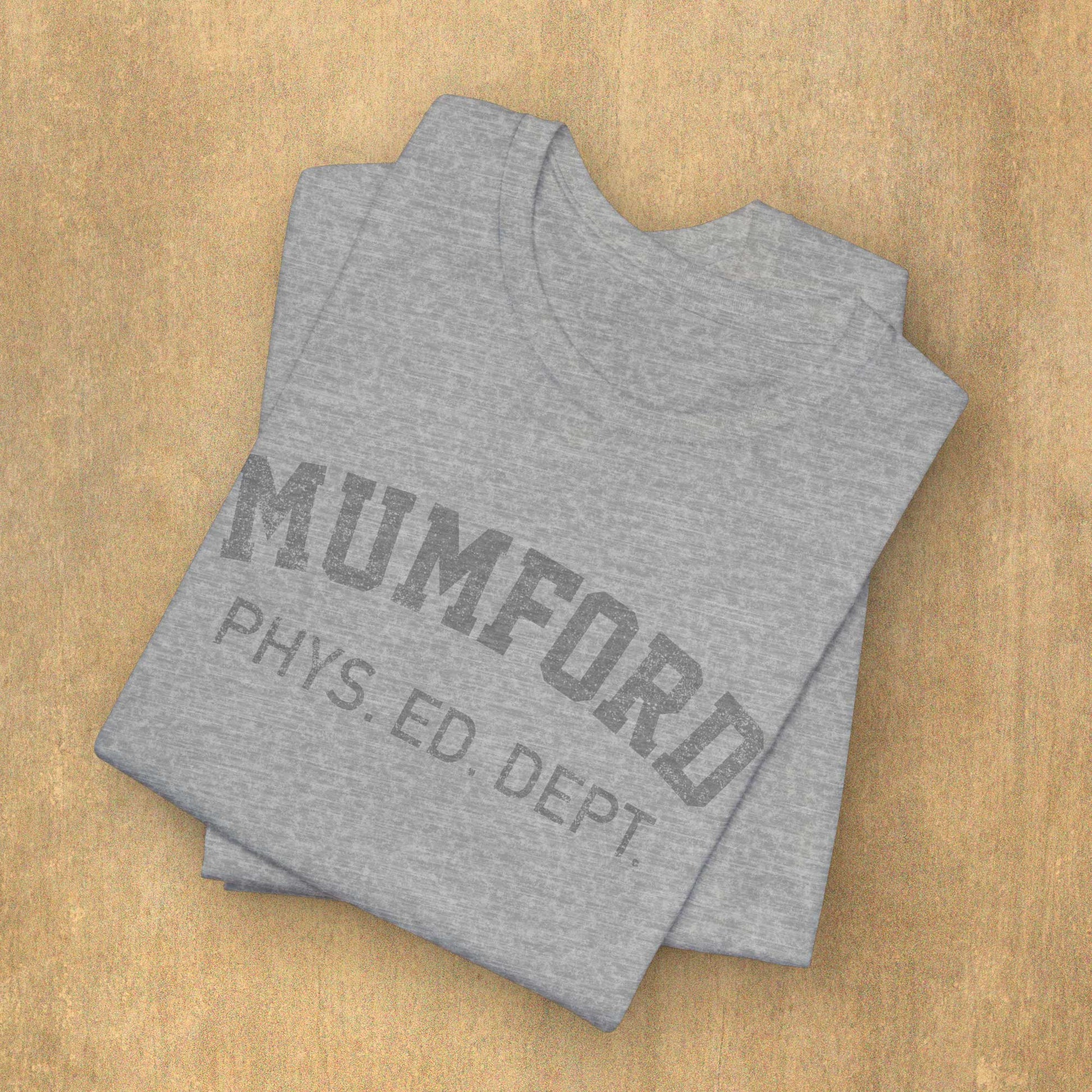 Folded Athletic Heather Grey Soft Bella+Canvas 3001 short-sleeve t-shirt gym tees featuring the Mumford Phys Ed logo graphic that Eddie Murphy wore as Axel Foley in the movie Beverly Hills Cop in a vintage distressed style, sold by ScriptedBrand.