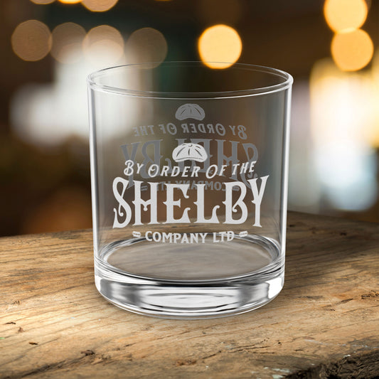 front view of 10 ounce Rocks Glass with Shelby Company LTD logo from Peaky Blinders printed on both sides, on a bar table