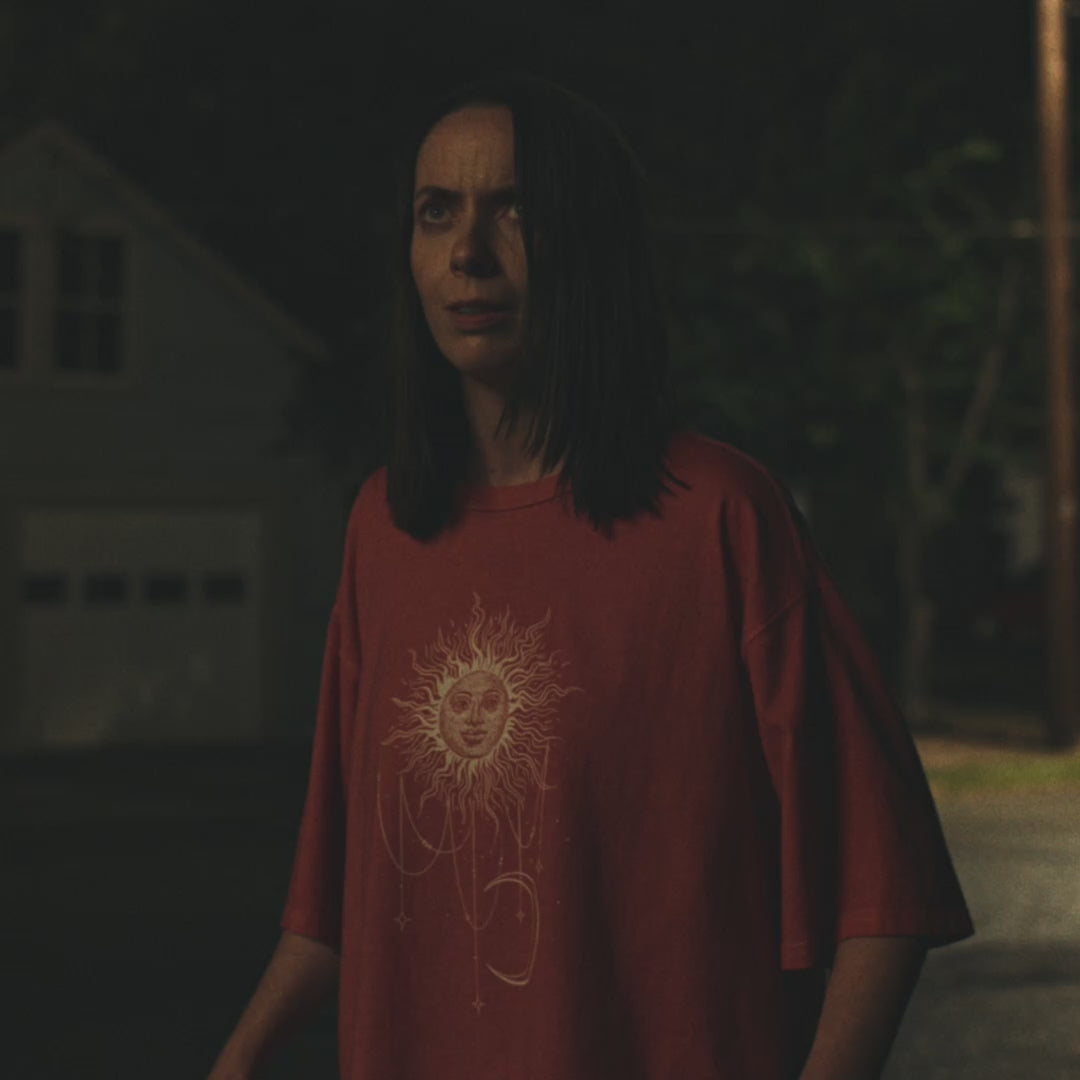 Video of red Comfort Colors tee with a celestial sun and crescent moon design, worn by Patricia in Widow's Bay S1E8