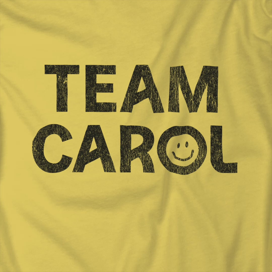 Video of yellow TEAM CAROL t-shirt inspired by Pluribus with vintage distressed smiley face graphic