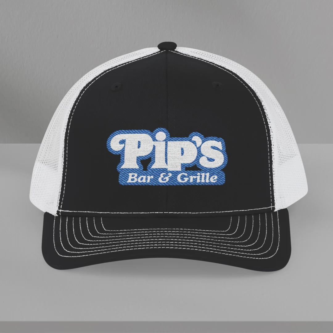 Video of Richardson 112 trucker hat with embroidered Pip’s Bar & Grille logo inspired by Severance.