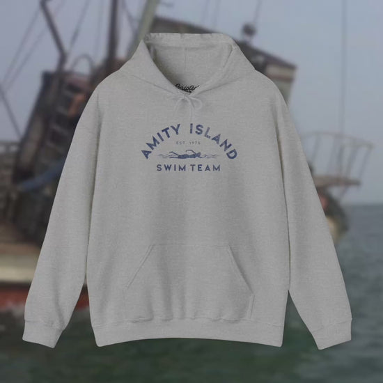 View of Soft Unisex Hoodie Heavy Blend Hooded Sweatshirts featuring an Amity Island Swim Team logo graphic, designed by ScriptedBrand, and  inspired by the movie Jaws in a vintage distressed style.